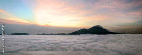Sunrise above clouds with a mountain volcano view