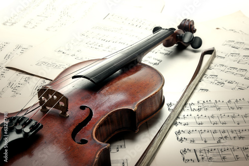 Old scratched violin with sheet music. Vintage style.