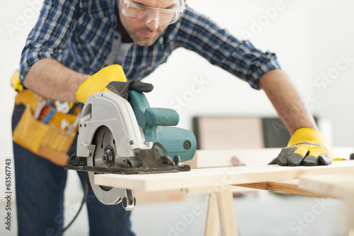 Carpenter working with circular saw