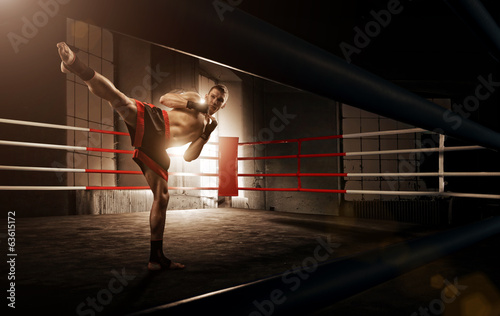 Young man kickboxing in the Arena