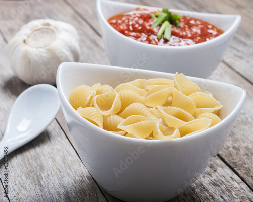 tomato sauce and pasta on wooden background
