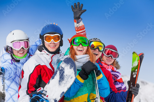 Positive friends with snowboards and skis