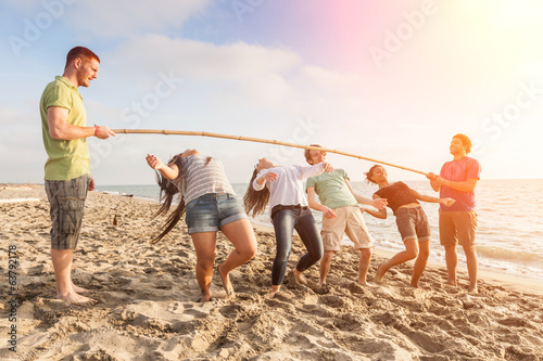 Friends Dancing Limbo at Beach