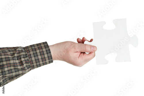 male hand holding big white paper puzzle piece