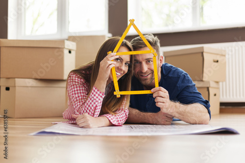 Couple in new apartment with home sign