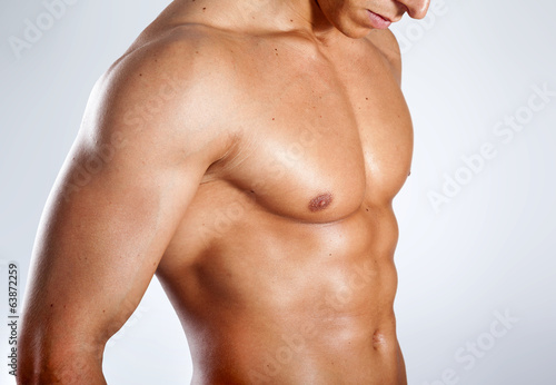 Healthy muscular young man on grey background