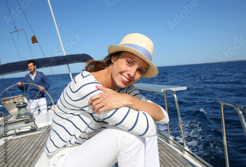 Beautiful woman with hat enjoying cruising on boat