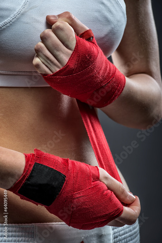 Boxing woman binds the bandage on his hand