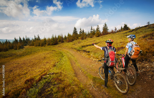 Two young bikers looking at the mountains