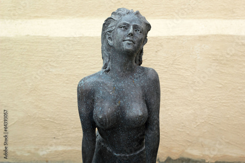 Statue of topless chest woman in english garden.