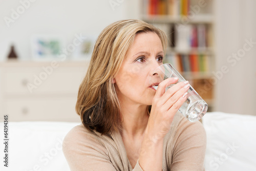 frau tinkt ein glas wasser zu hause