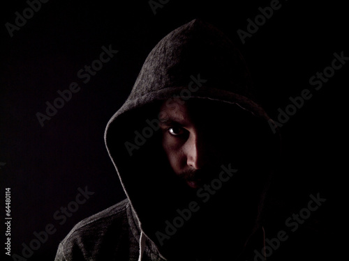 Low key image of a bearded man with a hoody