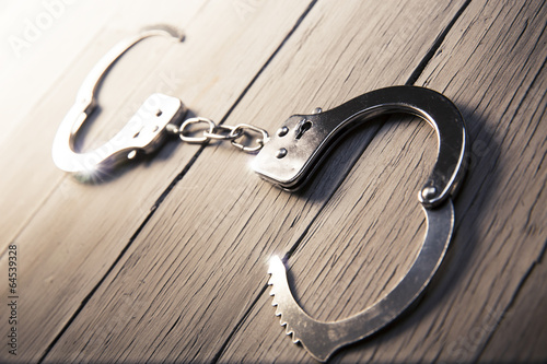 Open Handcuffs on a wooden background