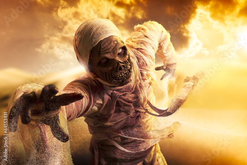 Scary mummy in a desert at sunset