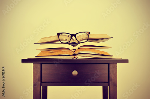 books and eyeglasses on a desk, with a retro effect