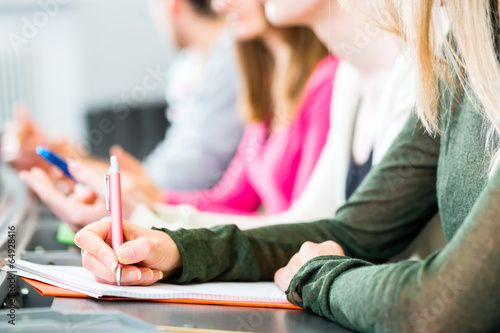 Studenten im Uni Hörsaal schreiben Klausur