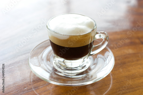 Hot espresso with milk and foam in cup.