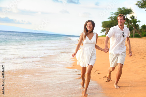 Beach couple on romantic travel honeymoon fun