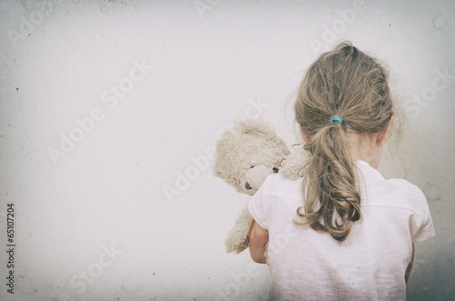 Little girl crying in the corner. Domestic violence concept.