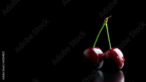 Two ripe red cherries