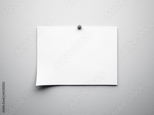 piece of blank paper tacked to white wall
