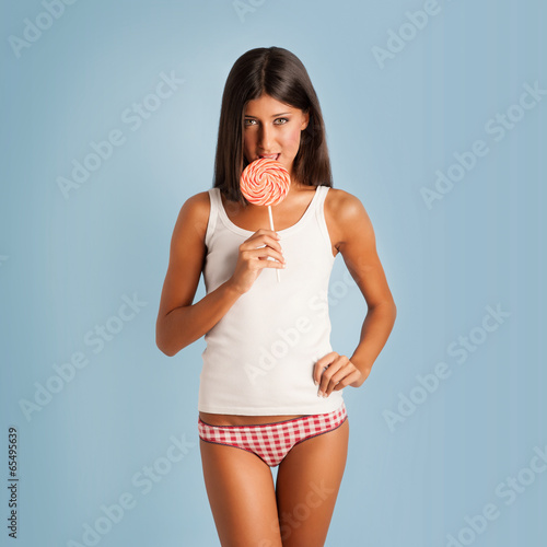 Happy woman portrait with lollipop against colorful blue backgro