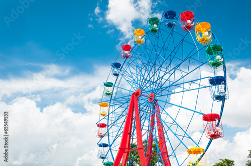 Giant ferris wheel against blue sky and white cloud