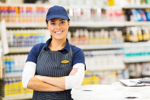 young female supermarket worker with arms crossed