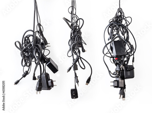 Cluster of messy chaotic power cables and adapters isolated on w