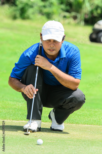 golf player on course putting, he aiming for his put shot
