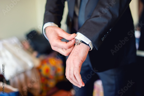 Close up of elegant man, groom hands with suits, ring, necktie