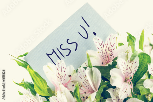 Bunch of white tiger lillies with a Miss u card