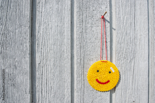 Happy yellow smiley hanging on a wall