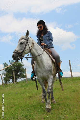 Outdoor picture of a woman on white horse