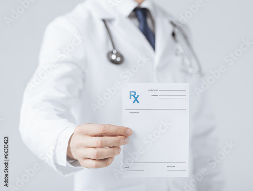 male doctor holding rx paper in hand