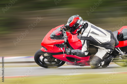 Motorcycle practice leaning into a fast corner on track