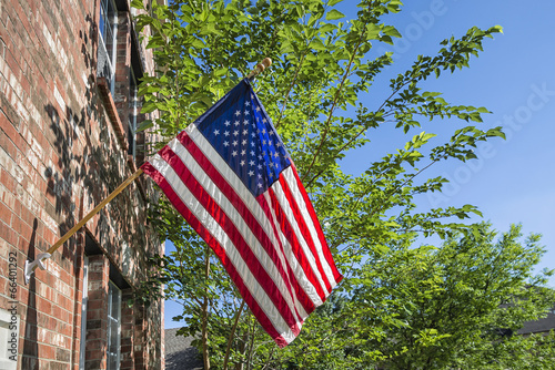 American flag in front of a brick home