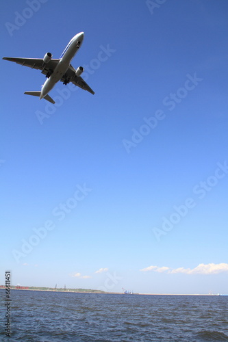 着陸する飛行機(B777)と海