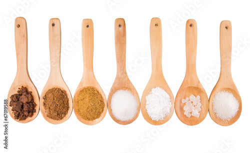 Various type of sugar on wooden spoon over white background