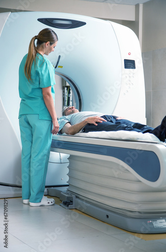 Open MRI scanner with man in 40s undergoing test