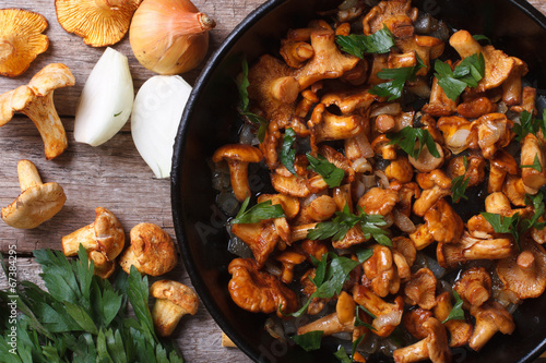 chanterelle mushrooms with onion and parsley in a pan top view