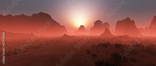 Red rocky desert landscape in the mist at sunset. Panoramic shot