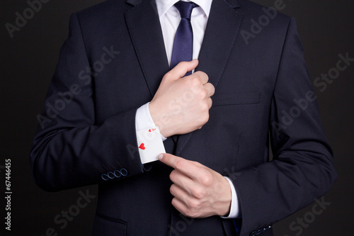 businessman with ace card hidden under sleeve