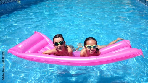 Niños en la piscina sobre colchoneta