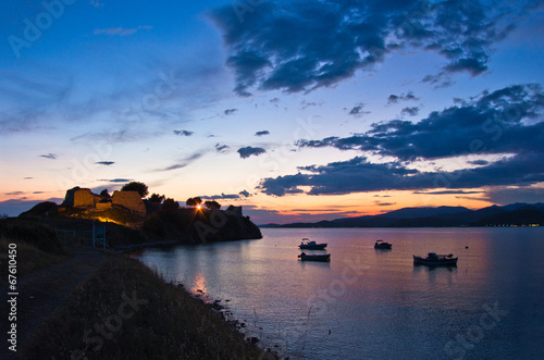 Sunset at Toroni bay with old roman fortress and fishing boats