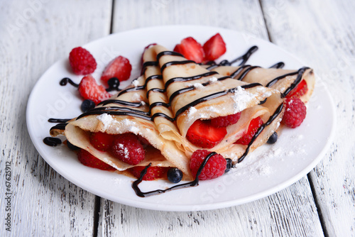 Delicious pancakes with berries on table close-up