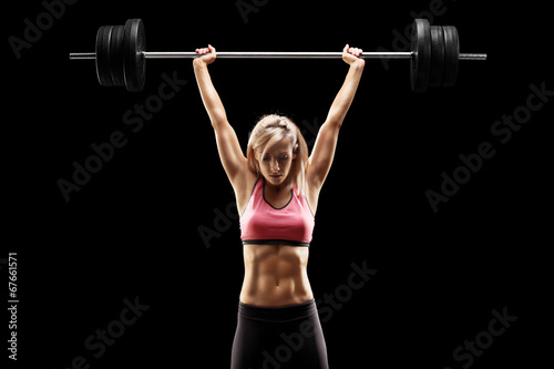 Muscular woman lifting a heavy barbell