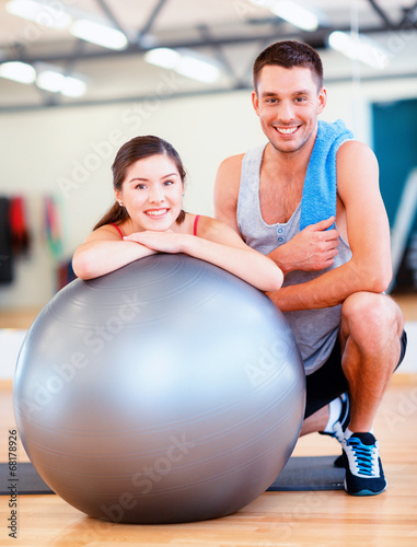 two smiling people with fitness ball