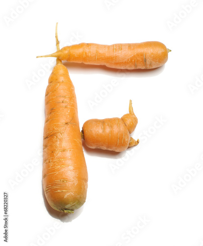 Alphabet letter F arranged from fresh carrots isolated