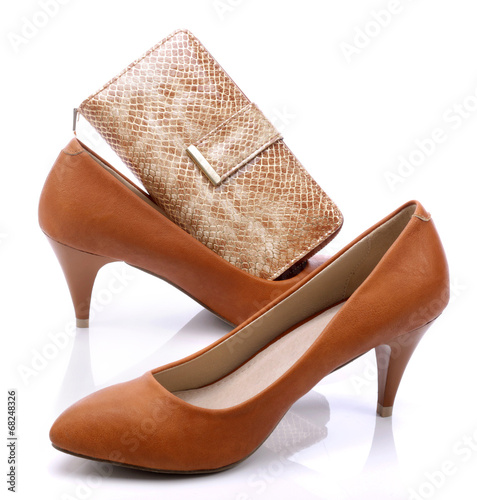 Women's shoes and gold wallet on a white background